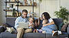 Eine Familie mit Kindern sitzt auf dem Sofa
