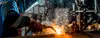 A skilled worker welds at a factory.