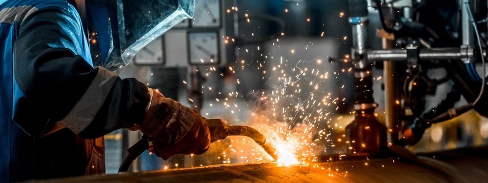 A skilled worker welds at a factory.