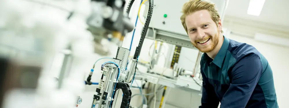 © Adobe Stock / Boggy A employee smiles into the camera.