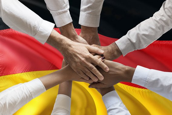 Mehrere Hände über der Flagge Deutschlands