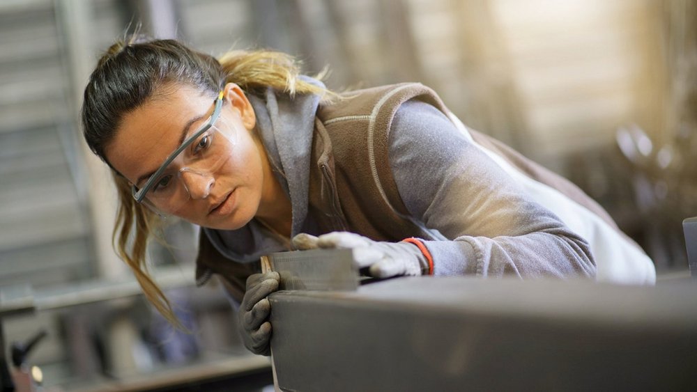 A woman is at a metalworking shop