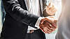 Two people shake their hands.