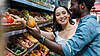 Two People are looking at fresh vegetables at the supermarket