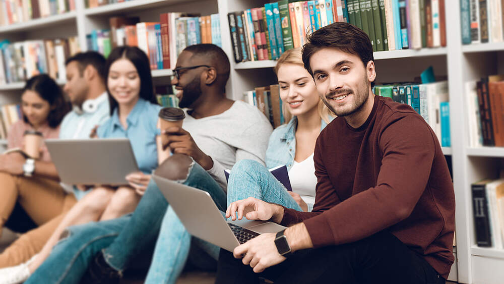 © Adobe Stock / freeograph several stduents sitting in a university library
