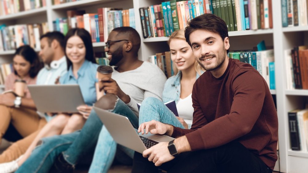 Mehrere Studenten sitzen in einer Universitätsbibliothek