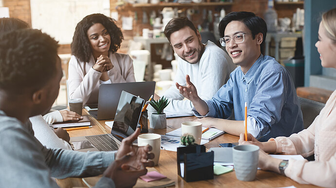 ©AdobeStock/Prostock-Studio Internationales Team berät sich an einem Tisch