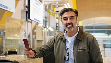 Smiling man standing in a modern office with colourful accents.