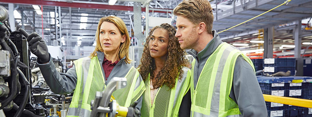 © iStock / Morsa Images Engineers discuss over automotive parts in a factory.